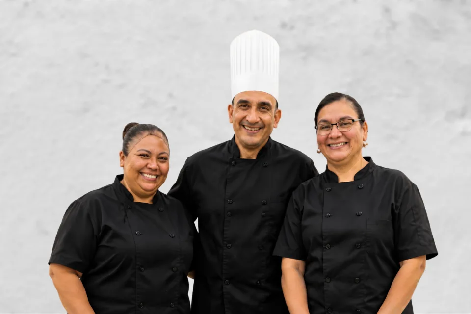 Chef Javier with two Mana Sabroso team members in uniform