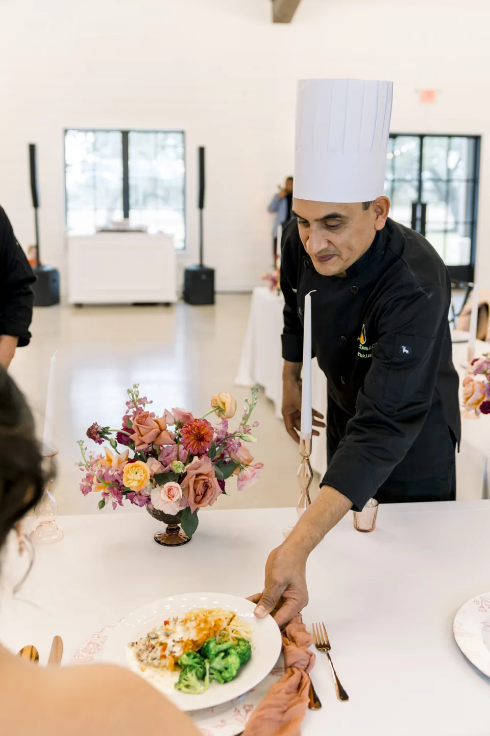 A chef serving a plated meal at a venue