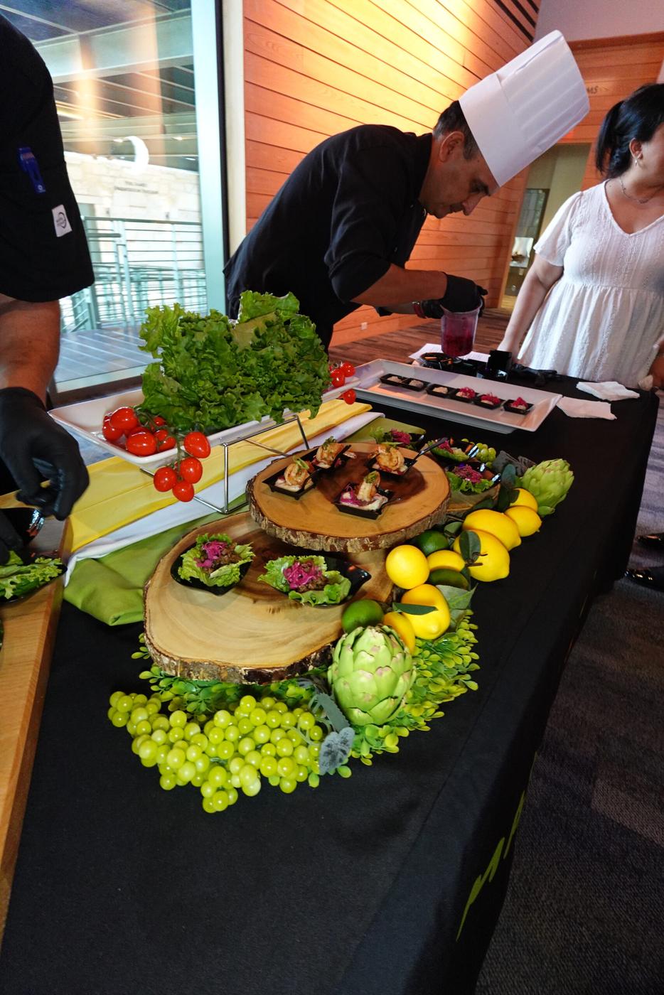 Chef Javier plating passed bites on wood-slice risers for cocktail hour.