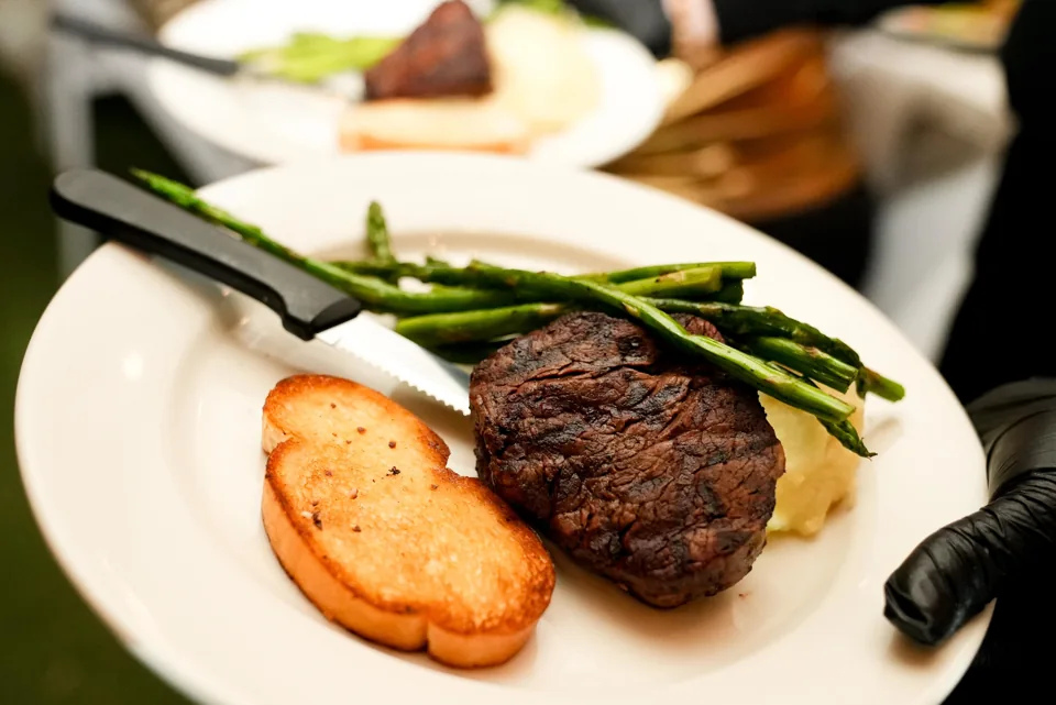 A plated steak entrée with green beans and toast, ready to serve