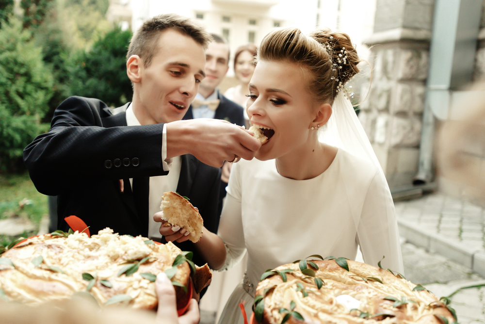Happy,Bride,And,Groom,Tasting,Cake,And,Laughing,,Funny,Moment,